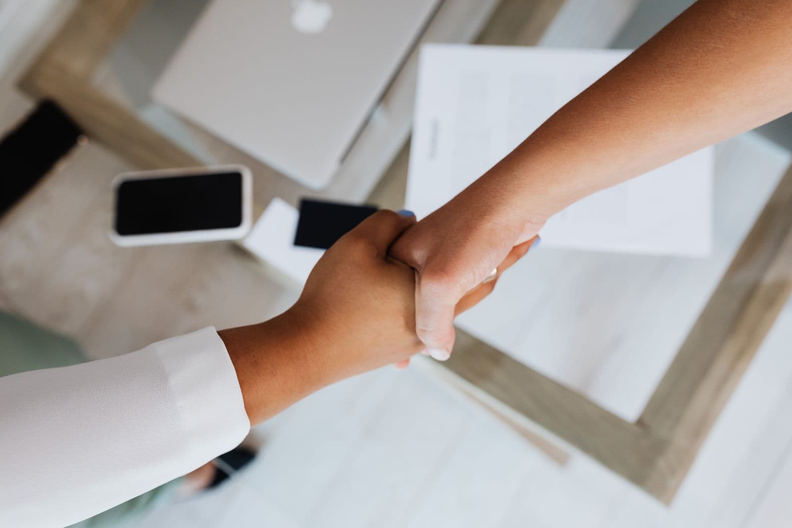 Two claims professionals shaking hands at a networking event